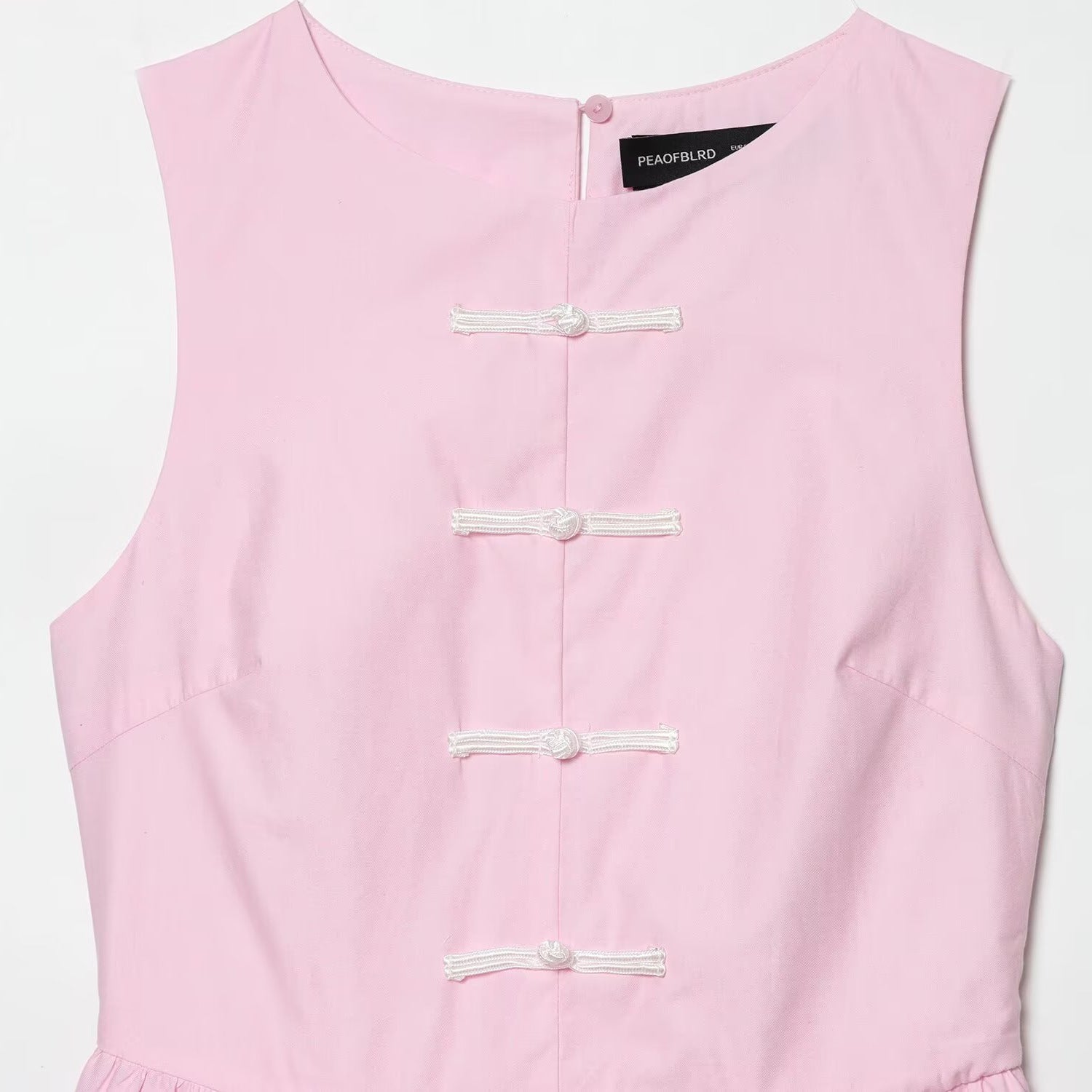 Sleeveless knot buckle embellished short skirt style hem top